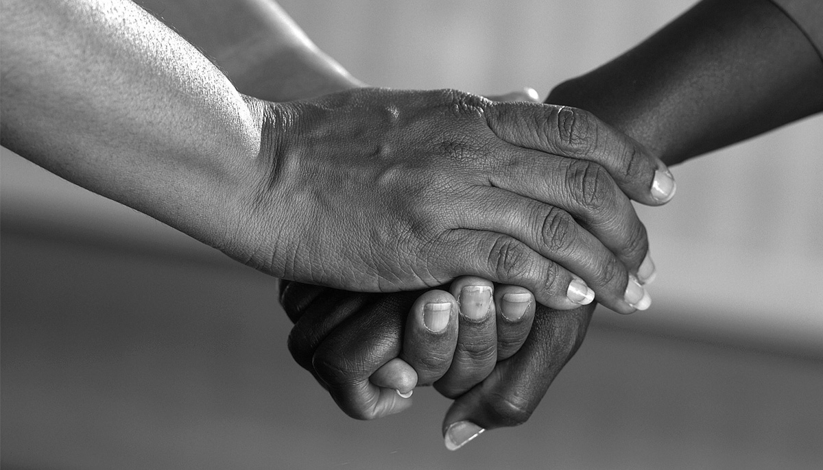 Two hands gently meeting in warm light